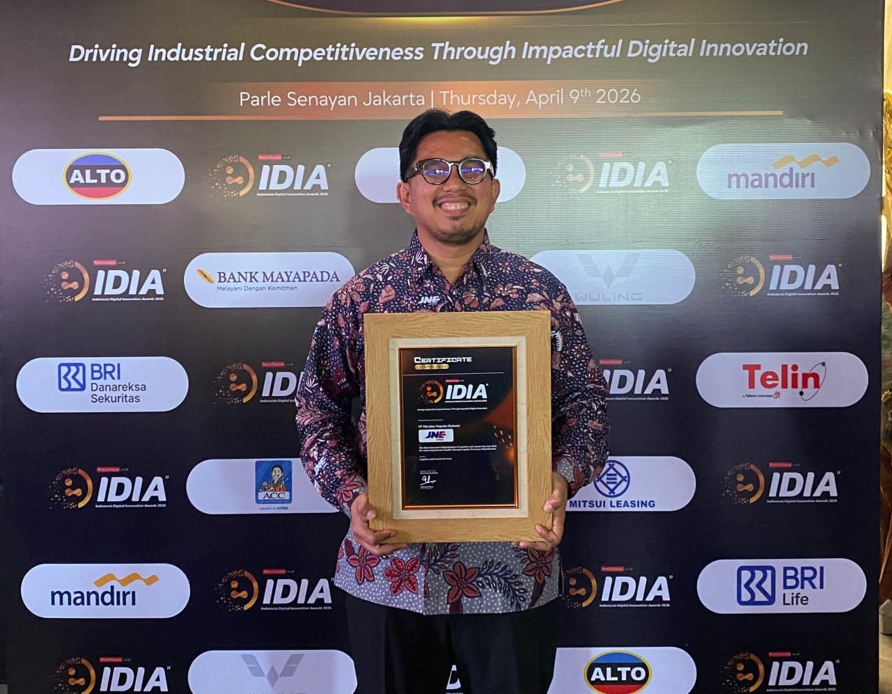 Perwakilan JNE Kurnia Nugraha saat menerima plakat penghargaan Indonesia Digital Innovation Awards 2026 di Jakarta.