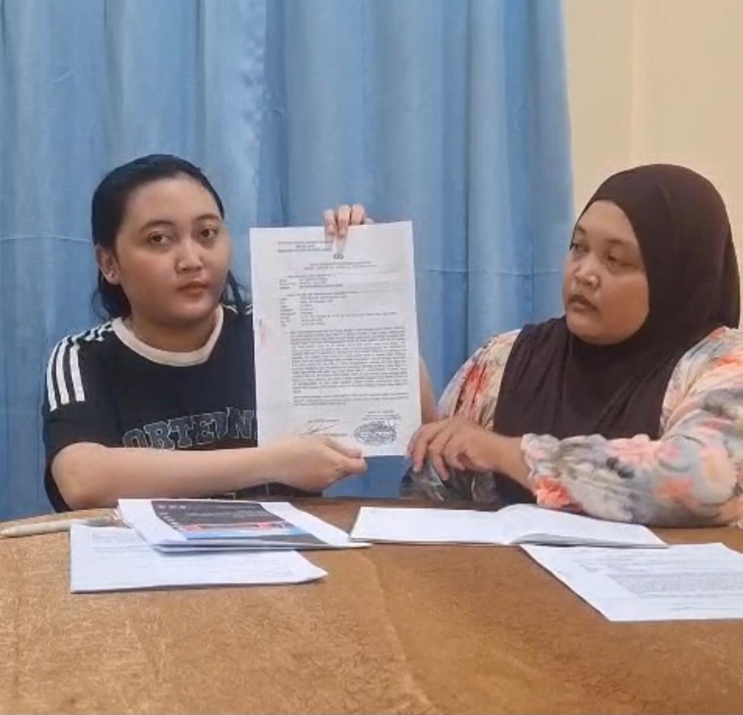 Kuasa hukum Aji, Dr. Ir. Fikri Riza, menunjukkan surat tanda bukti laporan di Mapolda Jambi.