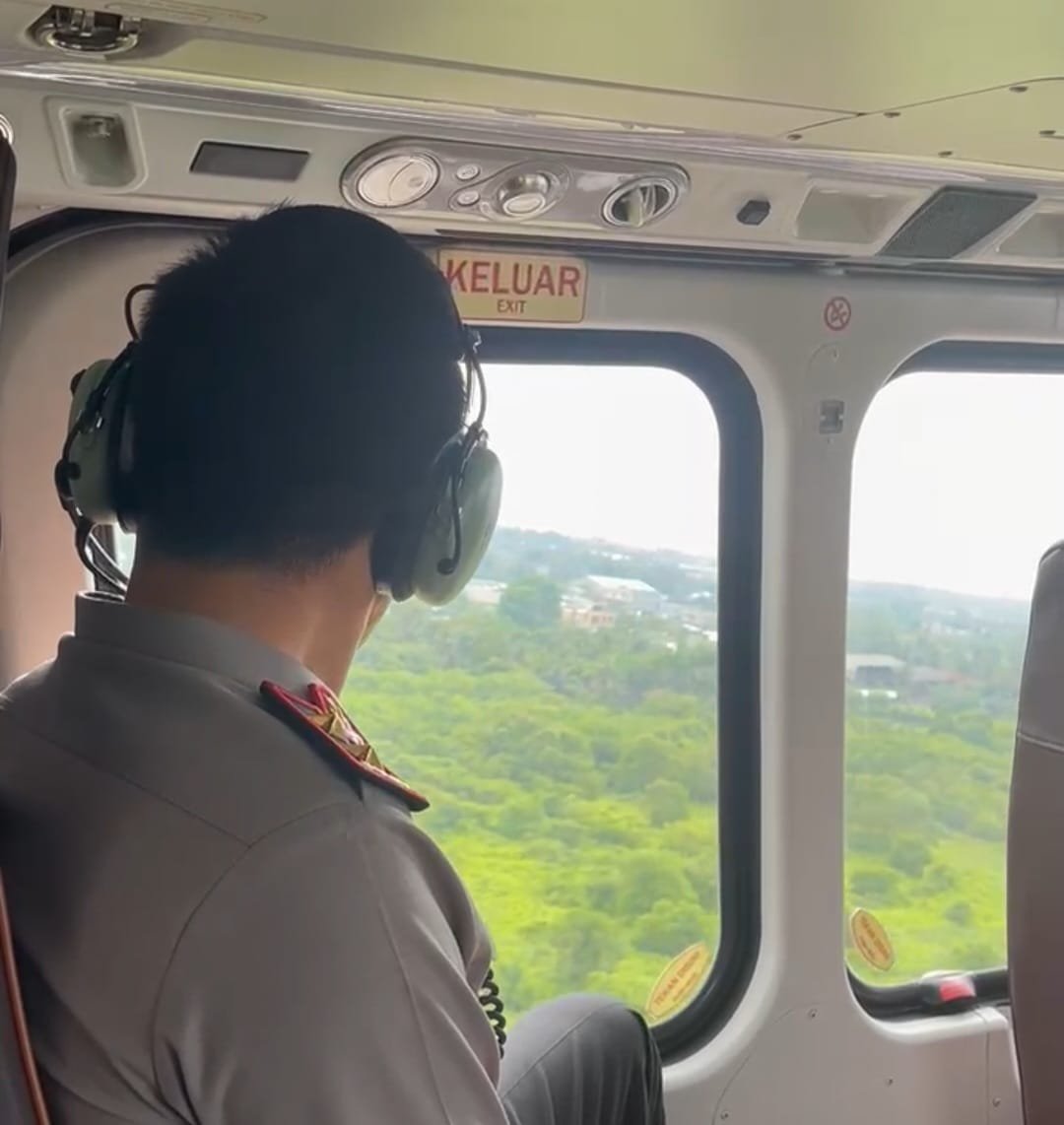 Kapolda Jambi Irjen Pol. Krisno H. Siregar memantau lahan melalui jendela helikopter Polri.