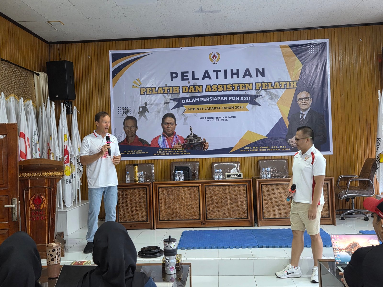 alt="Greg Wilson sedang memaparkan bagan latihan daya ledak dan kelincahan atlet di Aula KONI Provinsi Jambi"