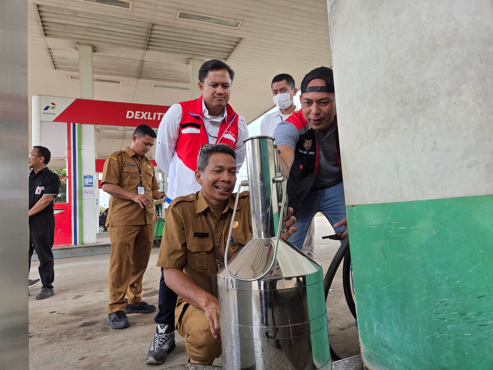 alt="Sales Branch Manager Pertamina Patra Niaga Abdillah Rorke bersama Iptu Dhea Cakra Tirta memeriksa monitor dispenser SPBU Jambi"