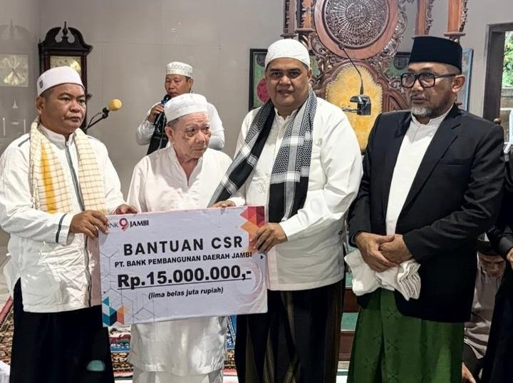 alt="Direktur Operasional Bank Jambi Zulfikar menyerahkan papan bantuan simbolis Rp15 juta kepada pengurus Masjid Jami’atussa’adah"