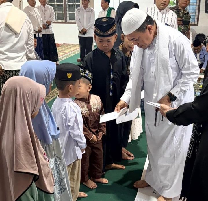 alt="Gubernur Jambi Al Haris memegang mikrofon memberikan arahan tegas di dalam masjid di depan jemaah"