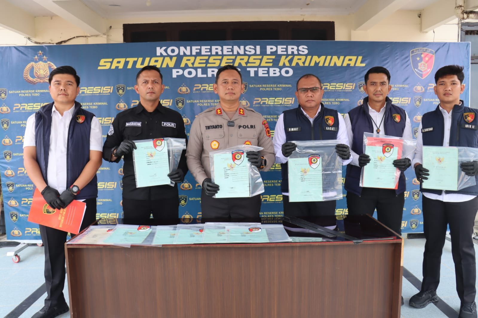 alt="Penyidik Unit Tipidkor Polres Tebo menunjukkan 11 bundel sertifikat tanah barang bukti korupsi"