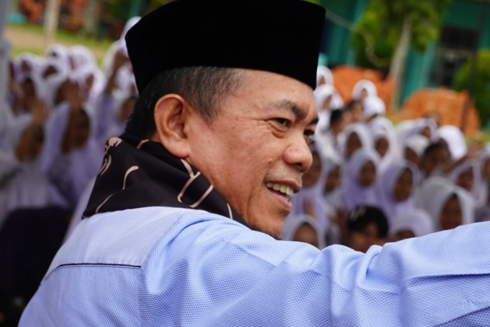 alt="Gubernur Jambi Al Haris menyaksikan prosesi penyerahan murid baru secara adat Melayu Jambi di aula sekolah"