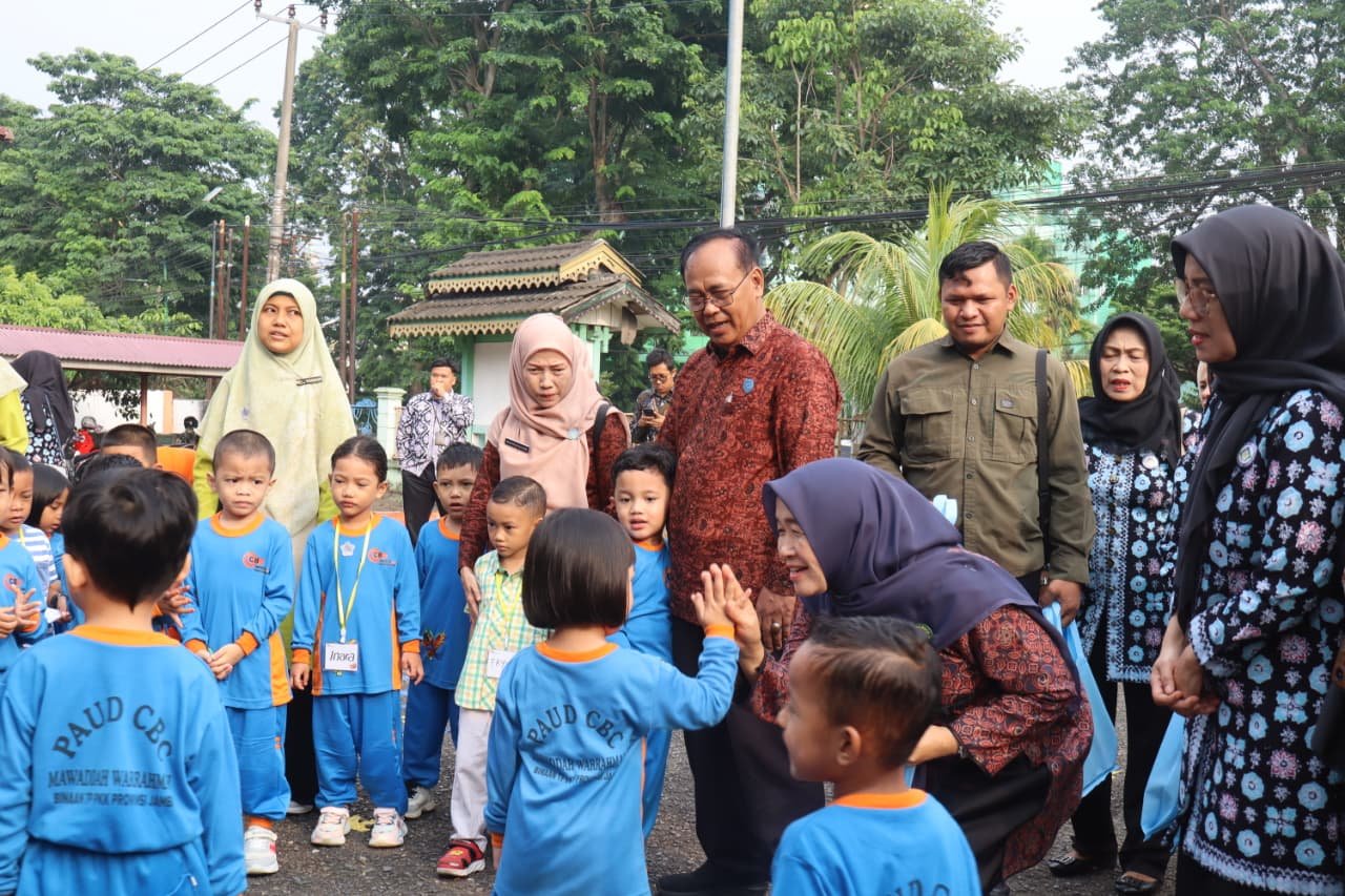 alt="Bunda PAUD Jambi Hesti Haris berinteraksi dan menempelkan stiker pada anak usia dini saat MPLS"