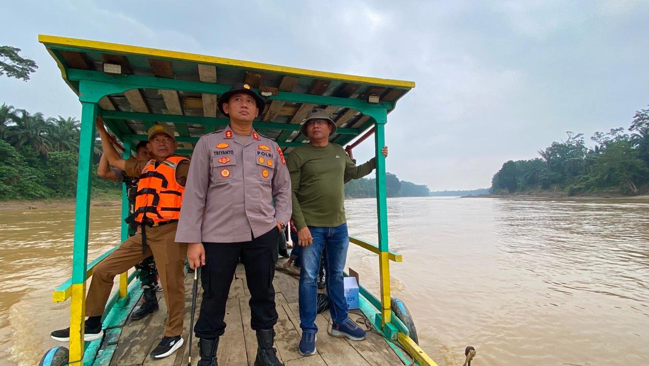 alt="Kapolres Tebo AKBP Triyanto berada di atas perahu karet memimpin penyisiran PETI di Sungai Batanghari"