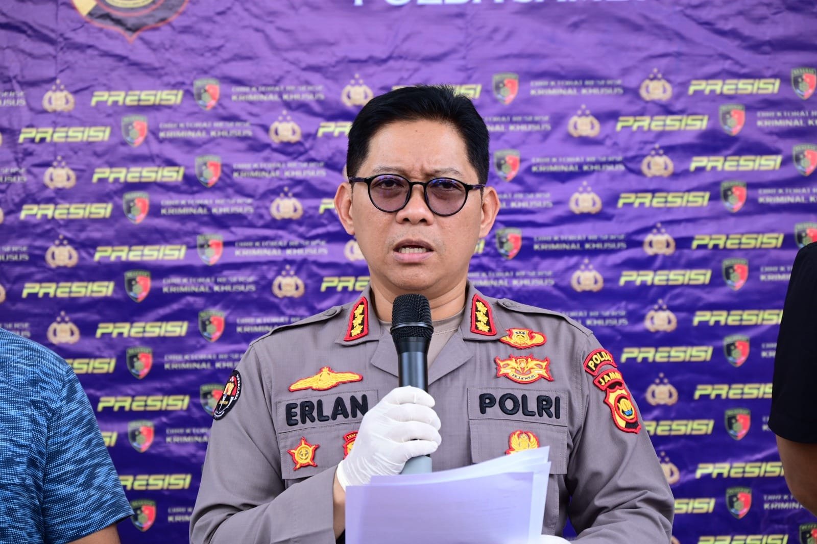 alt="Kabid Humas Polda Jambi Kombes Pol Erlan Munaji berbicara memegang mikrofon di depan wartawan di Media Center"