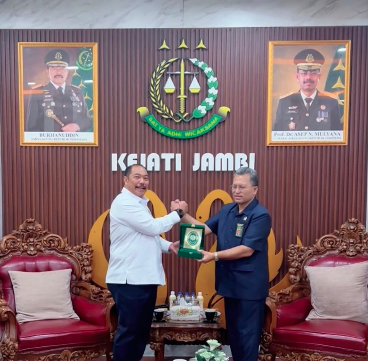 alt="Kajati Jambi Sugeng Hariadi dan Ketua Pengadilan Tinggi Jambi Marsudin Nainggolan berfoto bersama di ruang kerja Kajati"