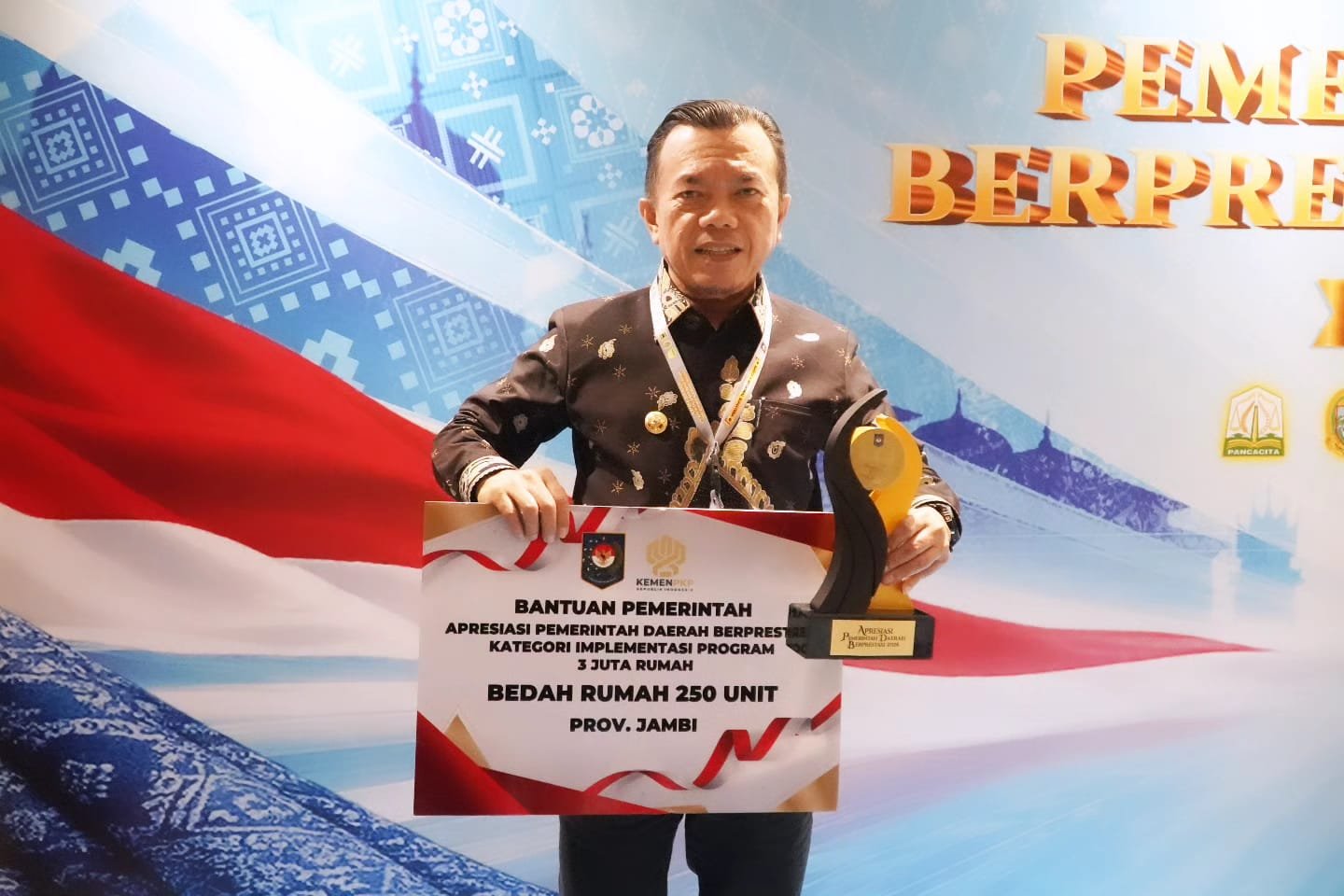 alt="Gubernur Jambi Al Haris memegang piagam penghargaan didampingi Mendagri Tito Karnavian dan Kepala BKP Muhammad Qodari"