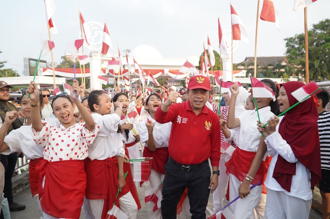 alt="Gubernur Jambi Al Haris dan Wagub Abdullah Sani mengikat bendera merah putih di pagar Jembatan Gentala Arasy"