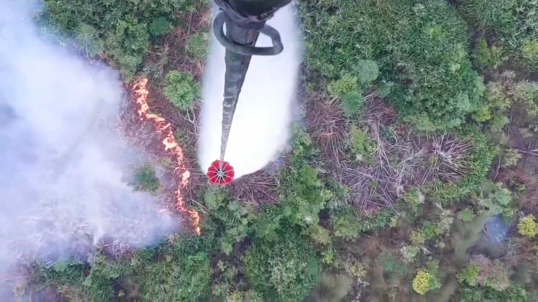 alt="Helikopter water bombing Satgas Udara Karhutla Jambi menjatuhkan air di titik kebakaran lahan Muaro Jambi"